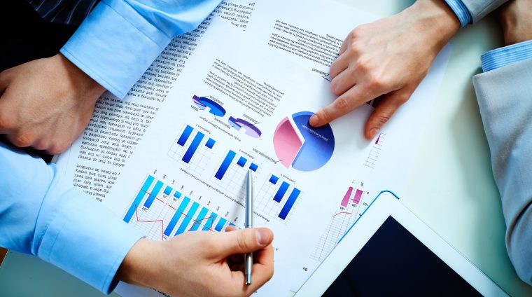 Close-up of female and male hands pointing at business document while discussing it